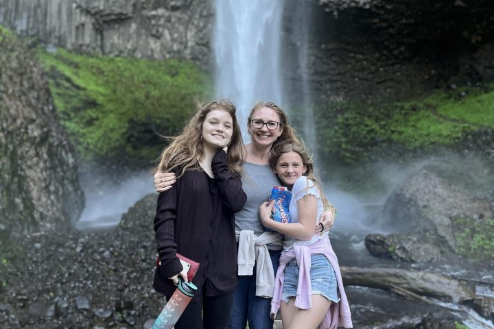 a woman standing next to a waterfall