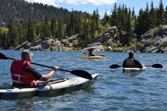 a man riding on the back of a boat in the water