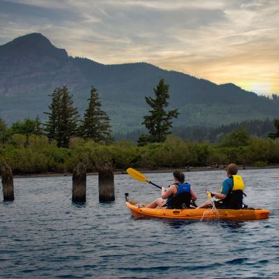 a group of people riding on the back of a boat in the water