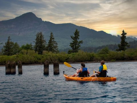 a group of people riding on the back of a boat in the water