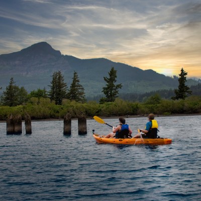 Two people on a kayak tour watching the sunset from a sunset kayak tour